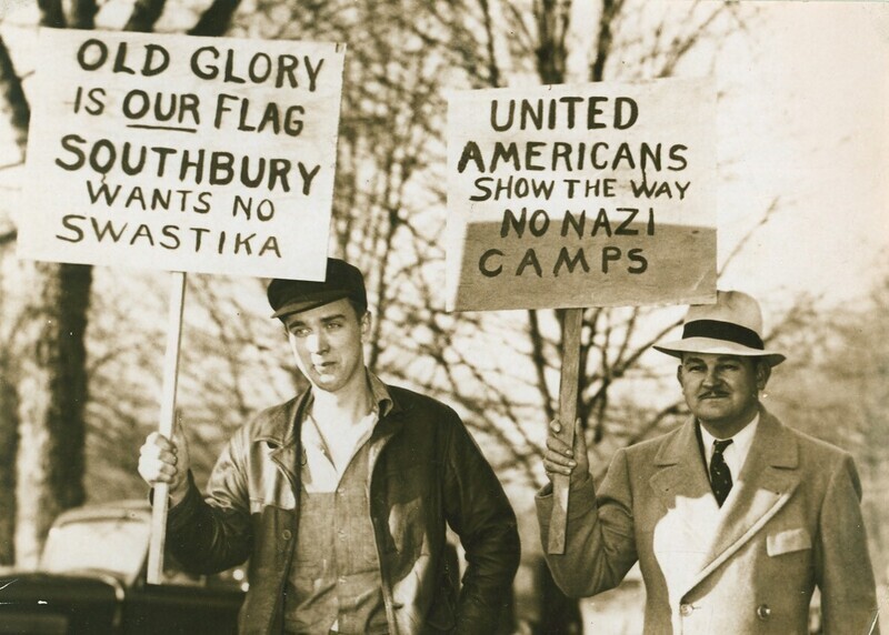 Two men carrying signs that read, "Old Glory is our Flag. Southbury wants no swastika."