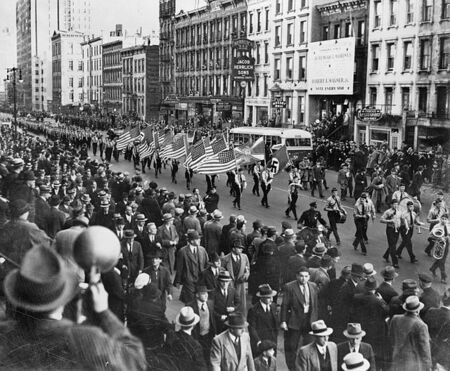 Parade with marchers carrying American and Swastika flags. 